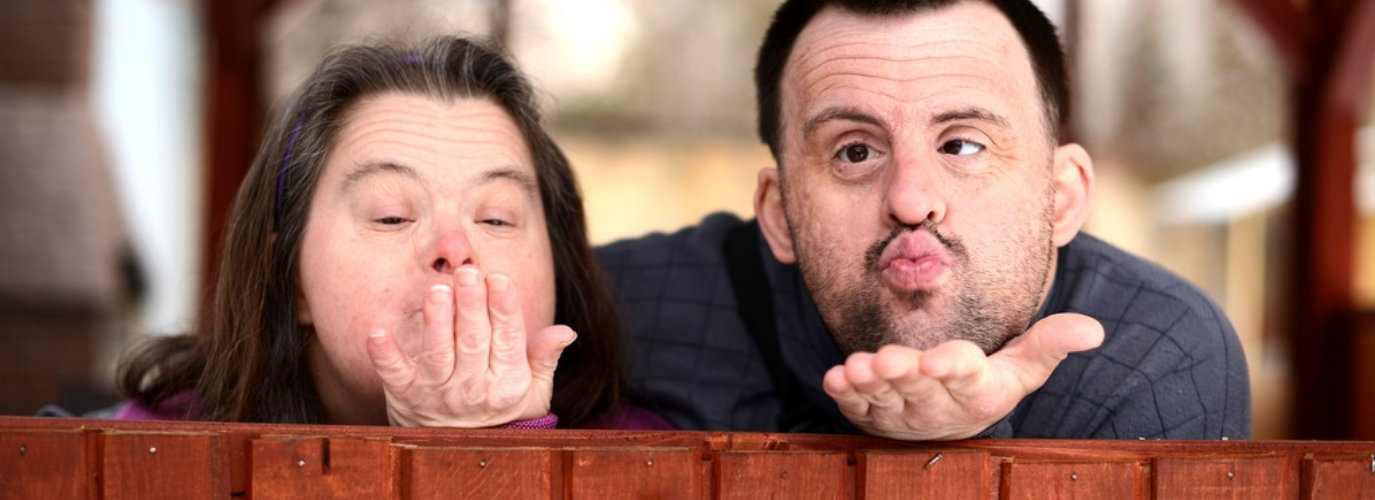 people with down syndrome using a flying kiss gesture
